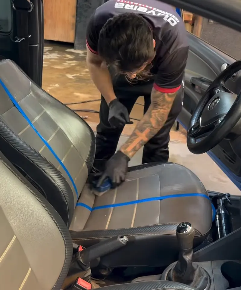 Limpeza de banco de couro com luvas dentro de um carro