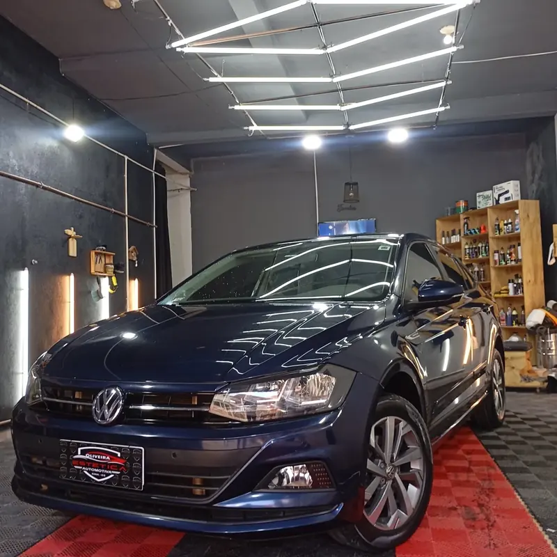 Volkswagen Polo azul no estúdio da Oliveira, sob o teto de luzes de LED