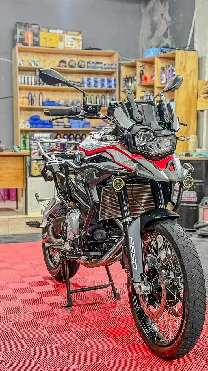 BMW F 850 GS no estúdio da Oliveira, com prateleiras de produtos ao fundo